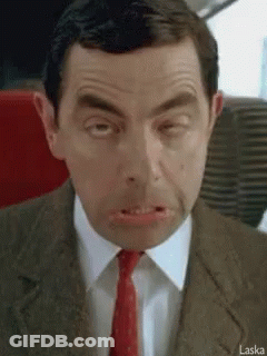 A Man In A Suit And Tie Is Making A Funny Face With His Mouth Open . GIF