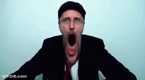 A Man In A Suit And Tie Is Making A Funny Face With His Mouth Open GIF