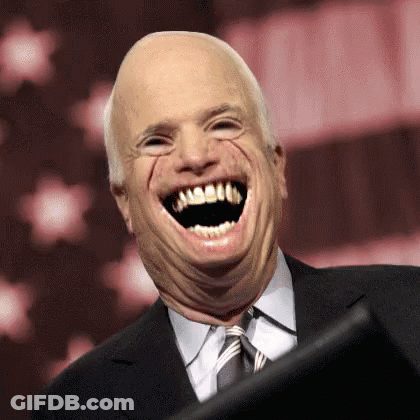 A Man In A Suit And Tie Is Making A Funny Face GIF