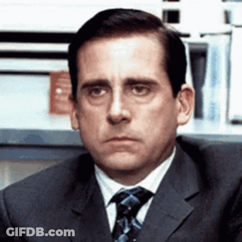 A Man In A Suit And Tie Is Making A Funny Face . GIF