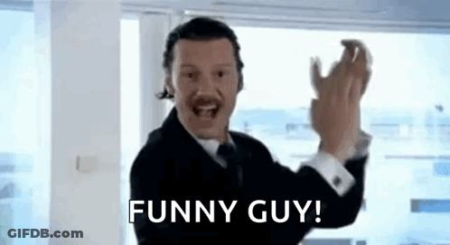 A Man In A Suit And Tie Is Making A Funny Guy Gesture While Wearing A Headset . GIF