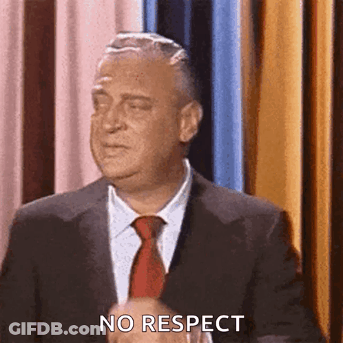 A Man In A Suit And Tie Is Making A No Respect Gesture . GIF