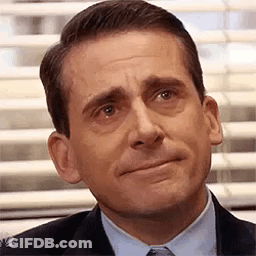 A Man In A Suit And Tie Is Making A Sad Face In Front Of A Window . GIF