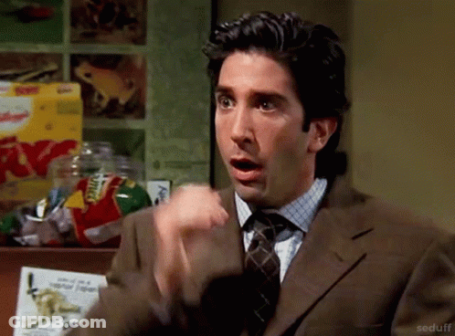 A Man In A Suit And Tie Is Making A Surprised Face . GIF
