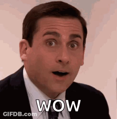 A Man In A Suit And Tie Is Making A Surprised Face While Saying Wow . GIF