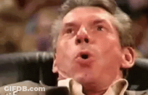 A Man In A Suit And Tie Is Making A Surprised Face With His Mouth Open . GIF
