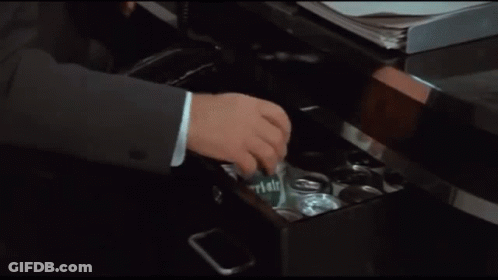 A Man In A Suit And Tie Is Opening A Can Of Beer GIF