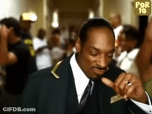 A Man In A Suit And Tie Is Pointing At Something GIF