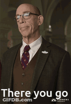A Man In A Suit And Tie Is Pointing At Something With The Words There You Go Below Him GIF
