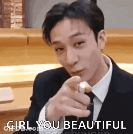 A Man In A Suit And Tie Is Pointing At The Camera While Saying `` Girl You Beautiful '' . GIF