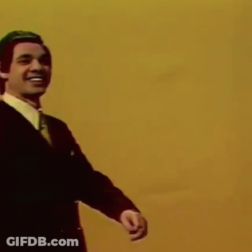Man In Suit And Tie Pointing And Smiling GIF