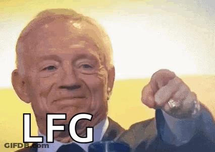 A Man In A Suit And Tie Is Pointing At The Camera With The Word Lfg On His Face . GIF