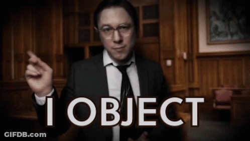 A Man In A Suit And Tie Is Pointing At The Camera With The Words I Object Behind Him GIF