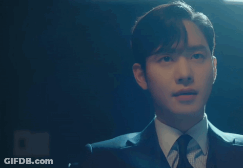 A Man In A Suit And Tie Is Pointing His Finger At Something GIF