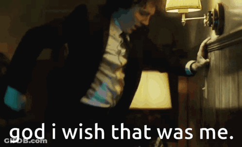 A Man In A Suit And Tie Is Reaching For A Lamp With The Words God I Wish That Was Me Written Below Him GIF