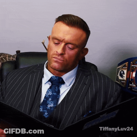 A Man In A Suit And Tie Is Reading A Book With Tiffanyluv24 In The Corner GIF