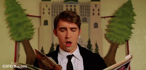 A Man In A Suit And Tie Is Reading A Magazine While Sitting In Front Of A Castle . GIF