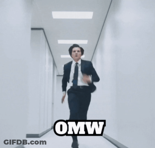 A Man In A Suit And Tie Is Running Down A Hallway With The Word Omw Written On The Bottom GIF
