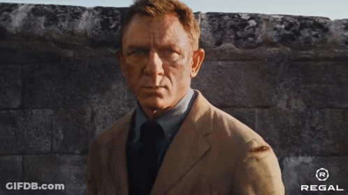 A Man In A Suit And Tie Is Running Down A Street With A Regal Logo In The Corner . GIF