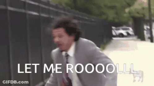 A Man In A Suit And Tie Is Running Down A Street With The Words Let Me Roooolll Written On It . GIF