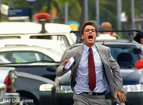 A Man In A Suit And Tie Is Running In A Crowded Street GIF