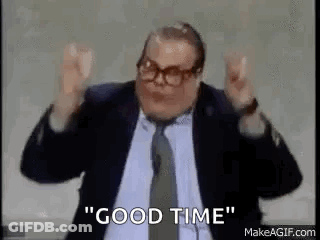A Man In A Suit And Tie Is Saying `` Good Time '' With His Arms In The Air . GIF