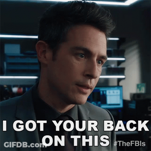 A Man In A Suit And Tie Is Saying I Got Your Back On This GIF