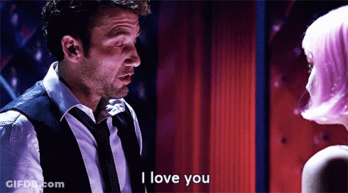 A Man In A Suit And Tie Is Saying I Love You GIF