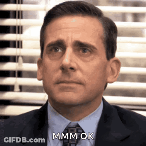A Man In A Suit And Tie Is Saying Mmm Ok . GIF