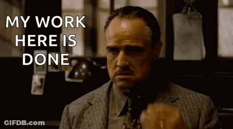 A Man In A Suit And Tie Is Saying `` My Work Here Is Done '' While Holding A Cigarette . GIF