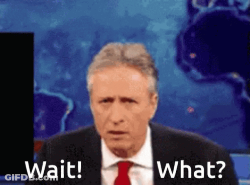 A Man In A Suit And Tie Is Saying Wait And What GIF