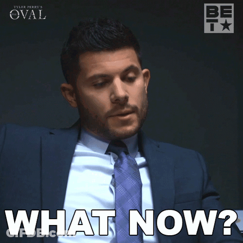 A Man In A Suit And Tie Is Saying What Now GIF