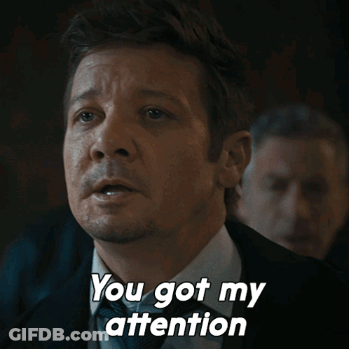 A Man In A Suit And Tie Is Saying " You Got My Attention " GIF