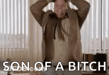 A Man In A Suit And Tie Is Screaming With His Hands On His Head And The Words `` Son Of A Bitch '' . GIF