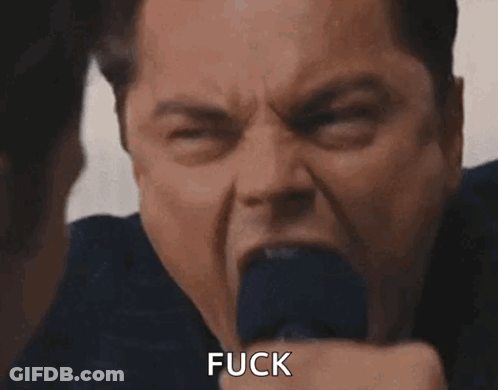 A Man In A Suit And Tie Is Screaming With His Mouth Open And Says Fuck . GIF