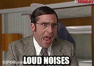 A Man In A Suit And Tie Is Screaming With His Mouth Open And The Words `` Loud Noises '' Written On His Face . GIF