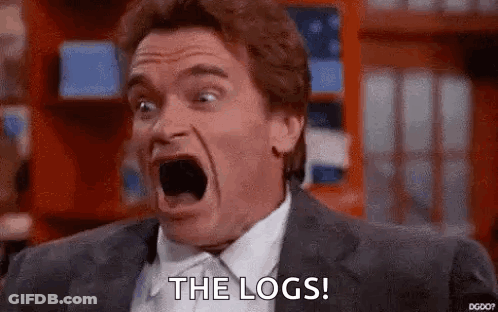 A Man In A Suit And Tie Is Screaming With His Mouth Open And The Words `` The Logs '' Written On His Face . GIF