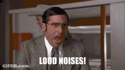 A Man In A Suit And Tie Is Shouting Loud Noises While Wearing A Headset . GIF