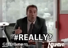 A Man In A Suit And Tie Is Sitting At A Desk And Saying Really ? GIF