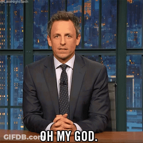 A Man In A Suit And Tie Is Sitting At A Desk And Says Oh My God GIF