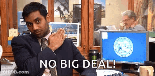 A Man In A Suit And Tie Is Sitting At A Desk In Front Of A Computer Monitor . GIF
