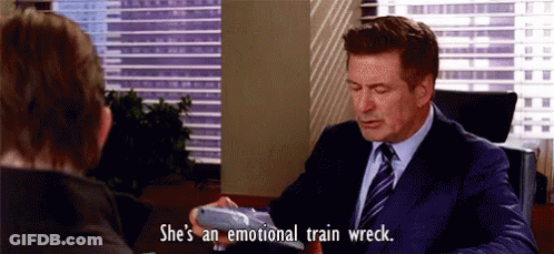 A Man In A Suit And Tie Is Sitting At A Desk With A Woman . GIF