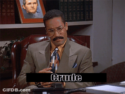 A Man In A Suit And Tie Is Sitting At A Desk With Crude Written On The Screen Behind Him GIF
