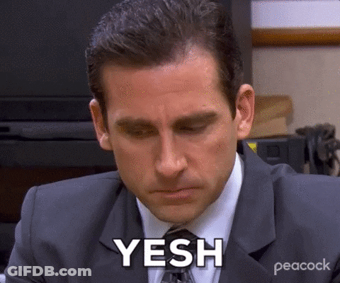 A Man In A Suit And Tie Is Sitting At A Desk With His Eyes Closed And Says Yesh . GIF
