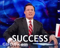 A Man In A Suit And Tie Is Sitting At A Desk With The Word Success On The Screen GIF