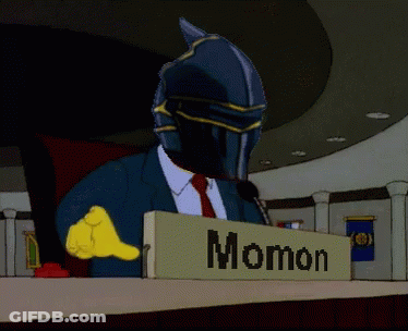 A Man In A Suit And Tie Is Sitting At A Podium With A Sign That Says Ainz Opal Gown GIF