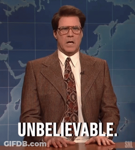 A Man In A Suit And Tie Is Sitting At A Table And Says Unbelievable . GIF
