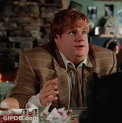 A Man In A Suit And Tie Is Sitting At A Table In A Restaurant Talking To Someone . GIF