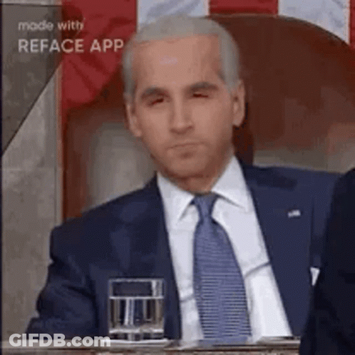 Man In Suit And Tie Sitting At Table GIF