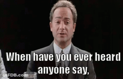 A Man In A Suit And Tie Is Sitting At A Table With A Glass Of Water And A Quote . GIF